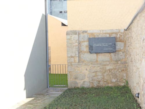 Entrada em pátio de pedra do apartamento Timeless Vacations no Porto com edifício amarelo moderno e portão verde