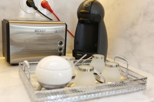 Zona de preparação de café e chá com torradeira Becken e máquina Krups na cozinha do apartamento no Porto