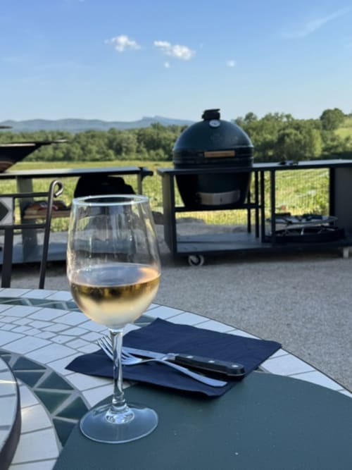 Verre de vin blanc sur la table de la terrasse du gîte L'arbre Qui Chante à Saint Sauveur de Cruzières, avec barbecue œuf bleu et