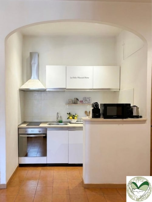 Cucina compatta e bianca nell'appartamento La Dolce Fiancati Home a Roma, con elettrodomestici moderni e pareti curve