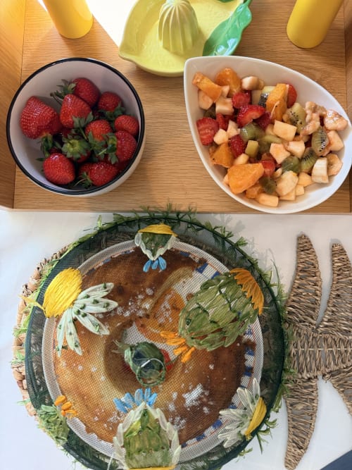 Présentation de fruits frais à l'Appart'Hôtel La Girafe avec framboises, salade de fruits et assiette décorée