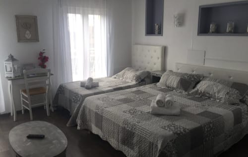 Chambre lumineuse de l'hôtel Luberon L'Hôtel à Apt avec lits jumeaux, décoration épurée et portes-fenêtres donnant sur balcon
