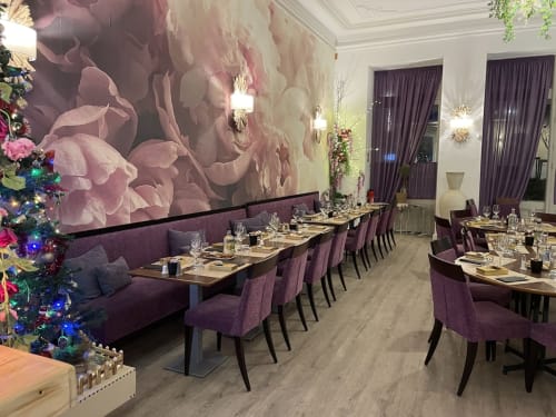 Élégante salle à manger de Luberon L'Hôtel à Apt avec sièges en velours violet, papier peint floral et décor festif de Noël