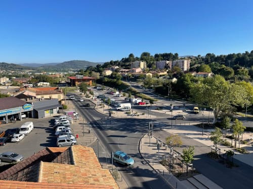 Vue aérienne d'Apt avec parking, rues, bâtiments résidentiels et collines environnantes en Provence, France