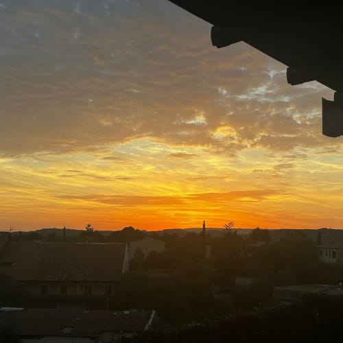 Vue du coucher de soleil doré sur les toits d'Apt et la campagne depuis le balcon de Luberon L'Hôtel