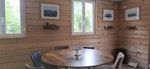 Salle à manger en bois avec table ronde et chaises au gîte Accolade à Châteaudun, vue sur le lac