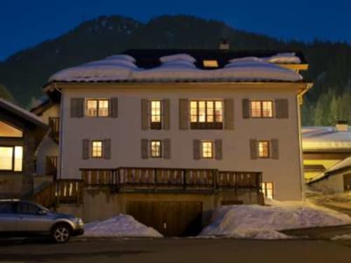 Le Chalet Savoyard au crépuscule, toit enneigé, fenêtres illuminées, cadre montagnard, La Plagne