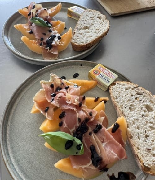 Elegante ontbijtborden bij L'arbre Qui Chante B&B met prosciutto, meloen, kappertjes, vers brood en boter in Saint