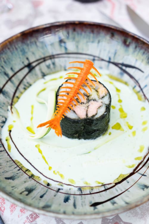 Elegant sushi nigiri with orange uni garnish on decorative plate at Pavillon Des Millesimes spa hotel in Lussac