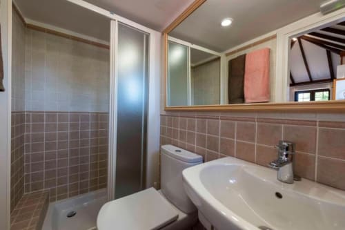 Baño moderno con ducha, inodoro y lavabo en apartamento Haller Homes en Canarias