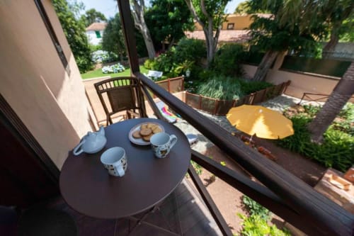 Desayuno en la terraza del apartamento Haller Homes en Canarias con té, galletas y vistas al jardín