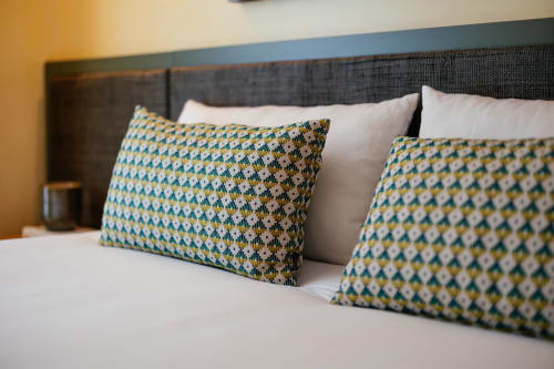 Quarto do hotel Douro Land com almofadas geométricas decorativas na cama e vista para a montanha, Peso da Régua