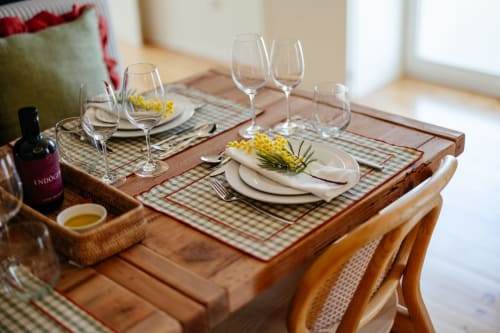 Elegante mesa de jantar no hotel Douro Land com talheres, taças de vinho e decorações florais amarelas em Peso da