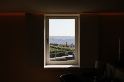 Vista da janela do hotel Douro Land em Peso da Régua com vinhedos, edifícios e montanhas