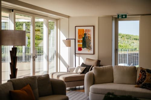 Elegante sala de estar moderna no hotel Douro Land com sofás bege, janelas do chão ao teto com vistas de vinhedos em Peso da