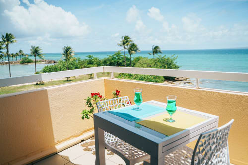 Oceanview balcony at La Perle Fleur D'epée with dining table overlooking turquoise Caribbean waters, Le Gosier