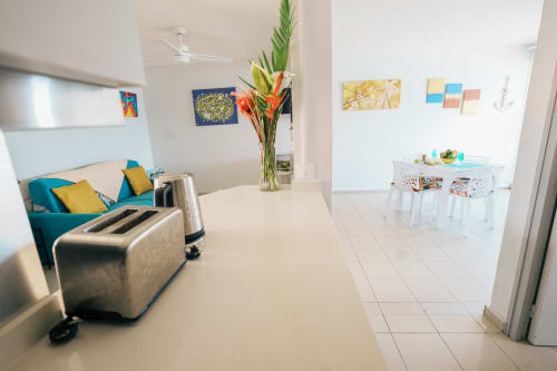 Modern apartment kitchen and living area at La Perle Fleur D'épée hotel in Le Gosier with colorful decor and sea view