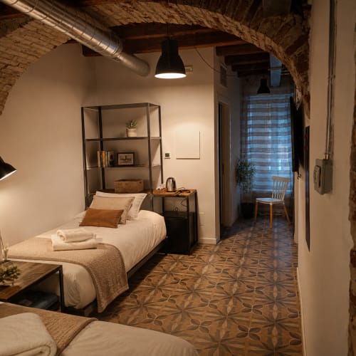 Modernes Schlafzimmer in den Apartments Borgovivobg Bergamo mit Backsteingwölbe, Einzelbett, Regalsystem und gemustertem Boden
