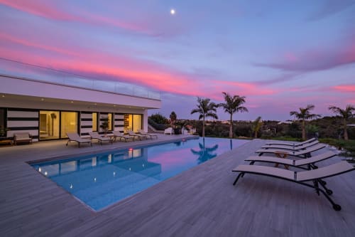 Pôr do sol luxuoso à beira da piscina no BlueHorizon, Albufeira. Vila moderna com piscina infinita, espreguiçadeiras e palmeiras