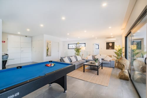 Apartamento moderno em Albufeira com mesa de bilhar azul, sofá cinzento e sala de estar luminosa e espaçosa na SignatureStays
