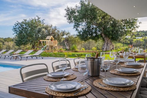 Elegante espaço de refeições ao ar livre no apartamento BlueHorizon em Albufeira com piscina, jardins e oliveiras centenárias