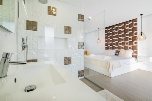 Suíte master contemporânea no BlueHorizon by SignatureStays em Albufeira com chuveiro aberto, acabamentos em azulejos geométricos