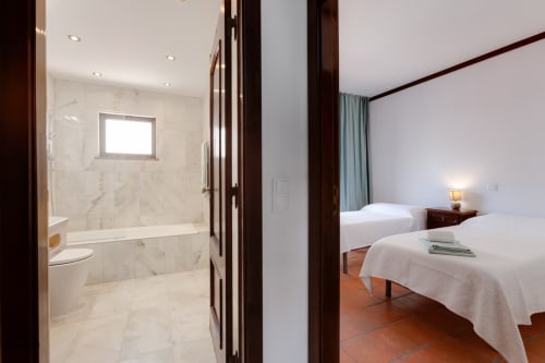Apartamento Beachtime Oura em Albufeira com quarto moderno com camas gêmeas e banheiro em mármore com chuveiro