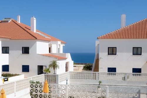 Apartamentos brancos de estilo mediterrâneo com telhados de barro na Beachtime Oura, Albufeira, com vista para o oceano azul
