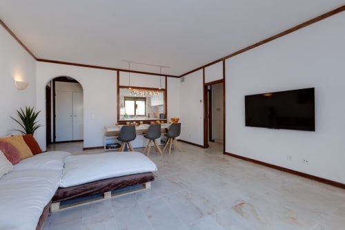 Apartamento estúdio moderno em SignatureStays Albufeira com cama, kitchenette, área de refeições e TV na parede