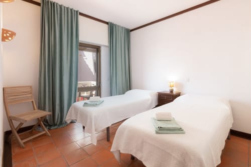 Quarto duplo no Beachtime Oura by SignatureStays, Albufeira com camas brancas, cortinas verdes e piso em terracota