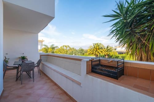 Terraço na cobertura do Farmvillage em Albufeira com zona de estar, churrasqueira e vista para palmeiras