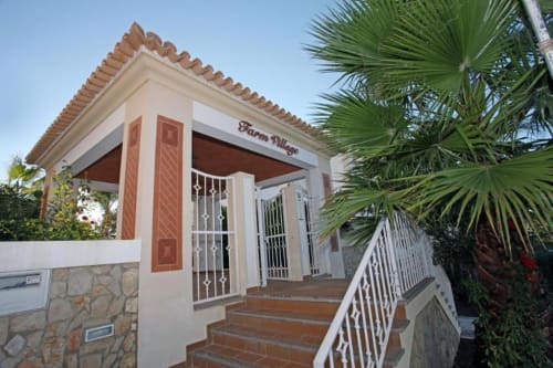 Entrada do apartamento Farm Village by SignatureStays em Albufeira com telhado de terracota e palmeiras
