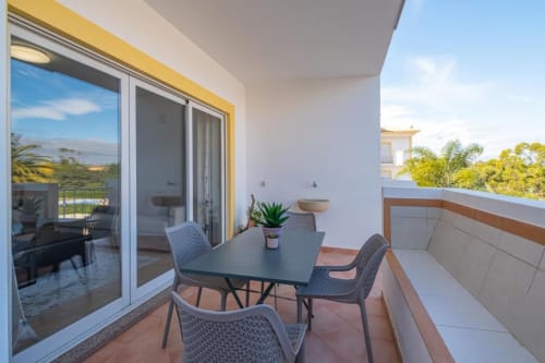 Terraço moderno da Farmvillage by SignatureStays em Albufeira com mesa de jantar, cadeiras e vista para o campo