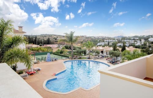 Piscina curva com terraço com vista para a paisagem de Albufeira no apartamento Farmvillage by SignatureStays