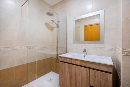 Banheiro moderno no Farmvillage by SignatureStays em Albufeira com chuveiro, lavatório e espelho