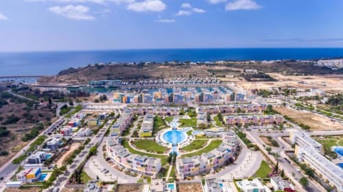 Vista aérea da Capetown Marina by SignatureStays em Albufeira com apartamentos coloridos, piscina central e ambiente mediterrâneo