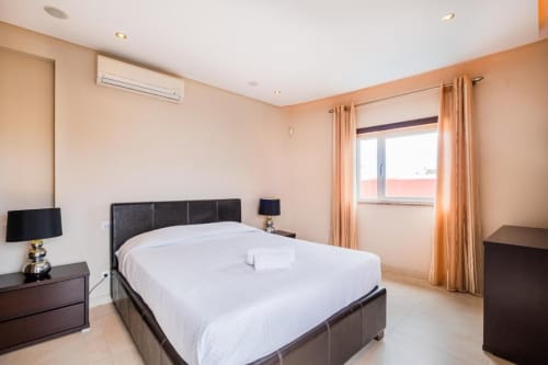 Quarto moderno em Capetown Marina pela SignatureStays em Albufeira com cama king, móveis escuros e vista para o oceano