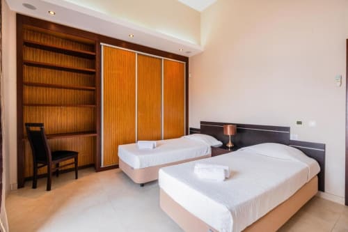 Dois camas de solteiro no apartamento Capetown Marina da SignatureStays Albufeira com guarda-roupa em madeira e mobiliário moderno