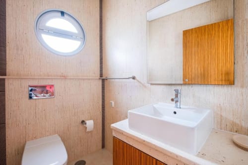 Banheiro moderno no apartamento Capetown Marina do SignatureStays Albufeira com pia branca, móvel em madeira e circular