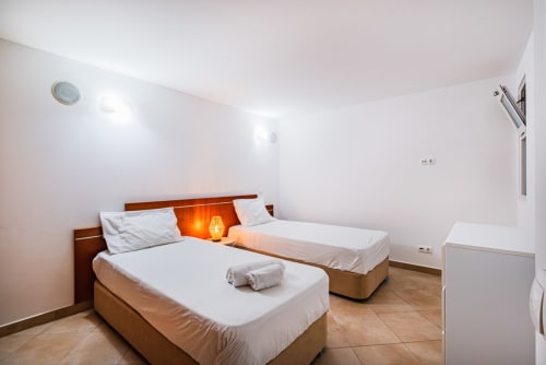 Quarto luminoso no Capetown Marina by SignatureStays em Albufeira com duas camas, cabeceira em madeira e piso em azulejos