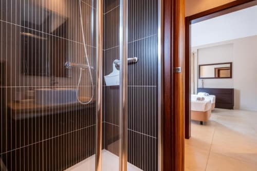 Moderno box de vidro com portas de listras verticais em apartamento Marina de Capetown, Albufeira