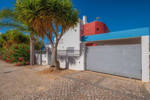 Apartamento Capetown Marina em Albufeira com paredes brancas, teto de cúpula vermelha, palmeira e entrada de paralelepípedos