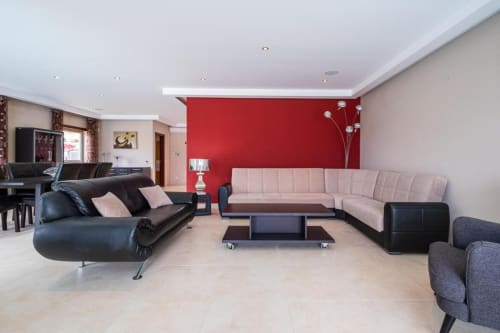 Sala de estar moderna no apartamento Capetown Marina em Albufeira com parede de destaque vermelha e mobiliário contemporâneo