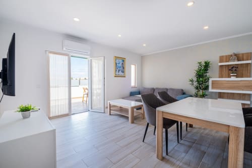 Apartamento moderno com planta aberta em Albufeira, zona de refeições, sofá, cozinha e acesso a terraço