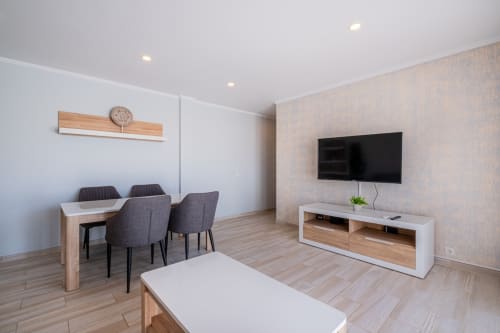Moderna sala de estar em apartamento no coração de Oura, Albufeira com mesa de jantar, TV e mobiliário contemporâneo