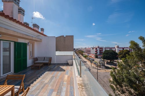 Terraço da cobertura do apartamento Heart of Oura em Albufeira com assentos, vistas da cidade e céu azul claro