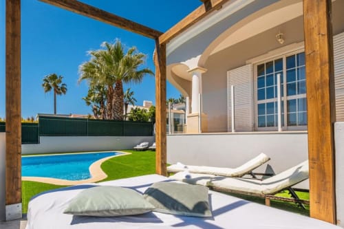Apartamento Vicente Mar no SignatureStays Albufeira: terraço à beira da piscina com espreguiçadeiras, piscina azul e design moderno branco