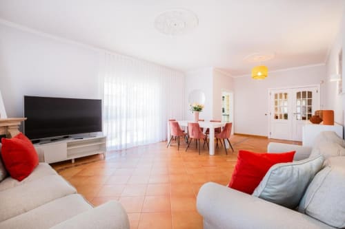 Apartamento SignatureStays Vicente Mar em Albufeira com sala de estar, mesa de jantar, TV, sofás e piso em terracota