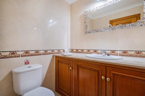 Banheiro moderno da Villa Rosal, SignatureStays Albufeira com pia de madeira e friso decorativo em azulejo