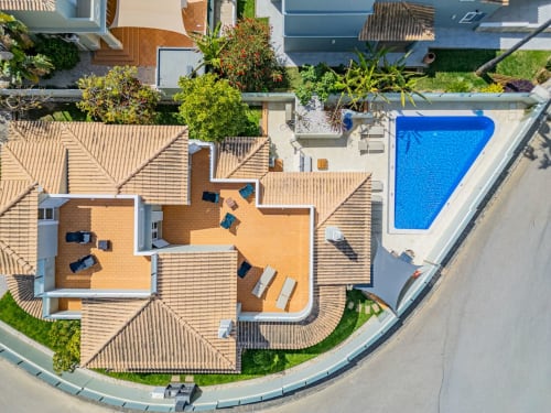 Vista aérea da Villa Rosal em Albufeira com telhado em terracota, pátio, piscina e jardins paisagísticos
